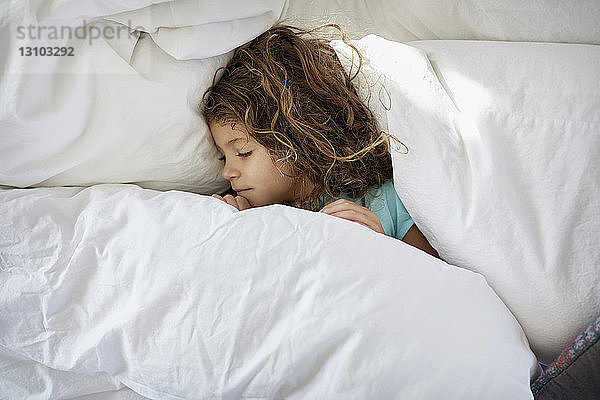 Hochwinkelansicht eines zu Hause auf dem Bett schlafenden Mädchens