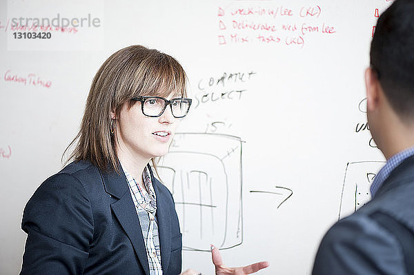 Geschäftsleute diskutieren im Büro per Whiteboard