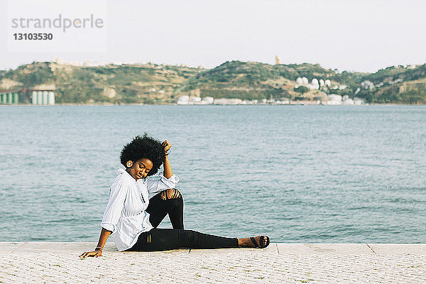 Junge Frau entspannt sich am Ufer des Tejo  Belem  Lissabon  Portugal