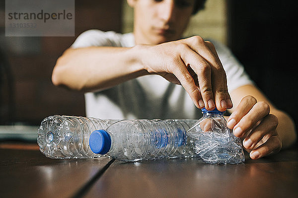 Jugendlicher recycelt Wasserflaschen