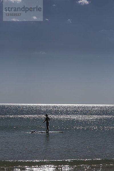 Silhouette Paddle Boarder auf sonnigen Sommer Ozean