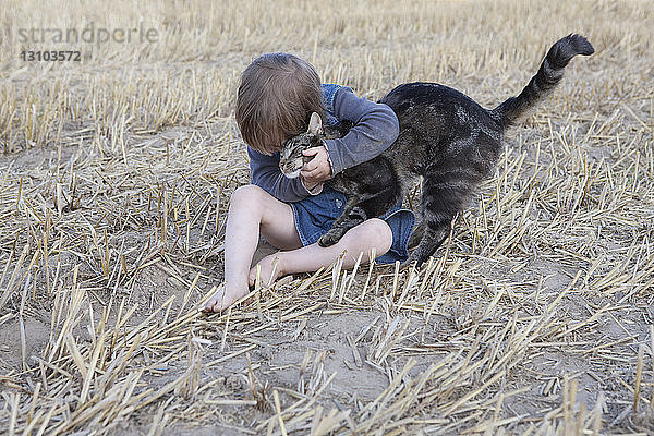 Zärtliches Mädchen  das eine Katze umarmt