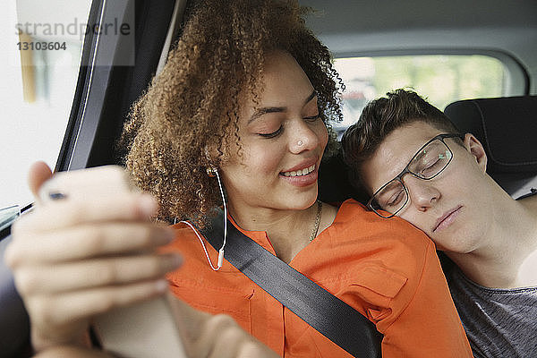 Junges Paar schläft und hört Musik im Auto