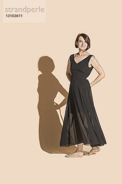 Porträt selbstbewusste  barfuß gehende Frau im schwarzen Kleid