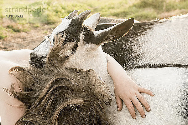 Mädchen umarmt Ziege
