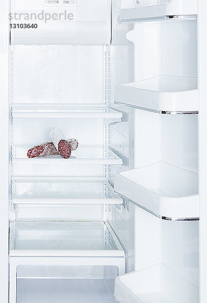 Salami im offenen  leeren weißen Kühlschrank