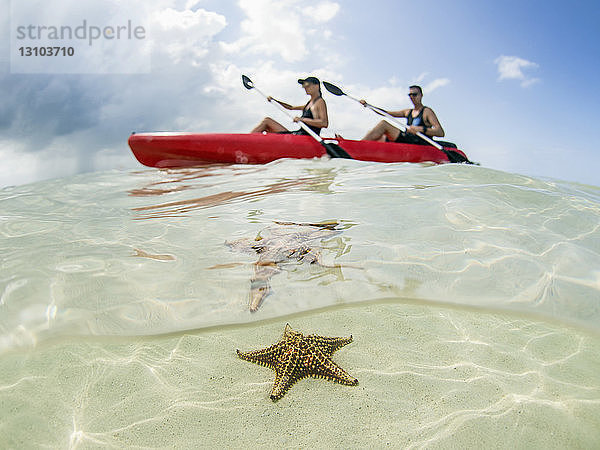 Paar beim Kajakfahren auf dem Meer am Starfish Beach  Grand Cayman  Cayman Islands