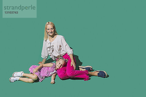 Porträt Mutter und Tochter entspannt auf grünem Hintergrund