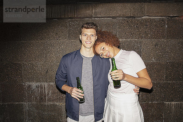 Porträt zärtliches junges Paar beim Biertrinken