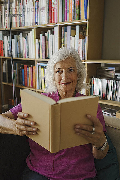 Porträt einer selbstbewussten älteren Frau  die ein Buch liest