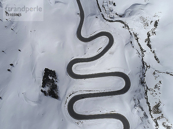 Blick von oben über den kurvenreichen Julierpass durch den schneebedeckten Berg  St. Moritz  Schweiz