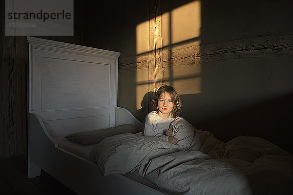 Portrait lächelndes Mädchen im Bett liegend