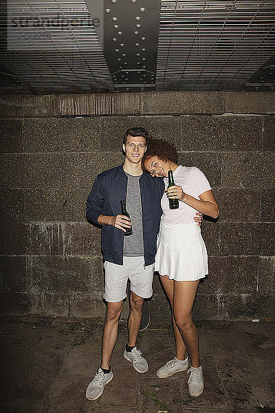 Portrait junges Paar trinkt Bier im Keller