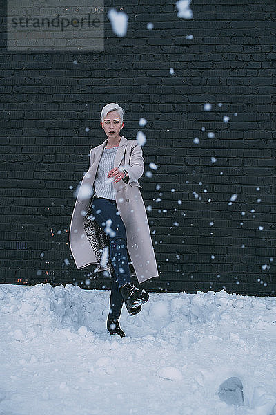 Porträt junge Frau  die Schnee tritt