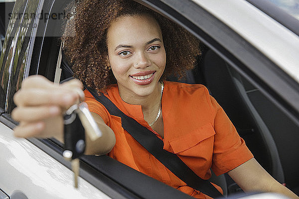 Portrait lächelnde junge Frau mit Autoschlüssel