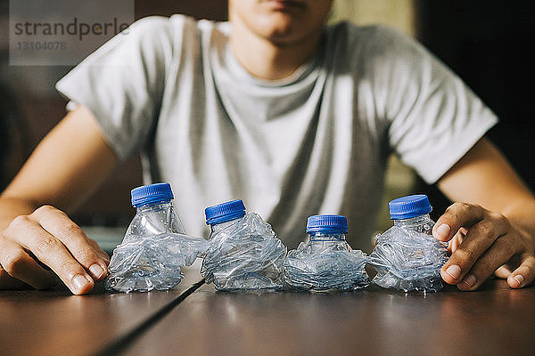 Jugendlicher recycelt Plastikwasserflaschen