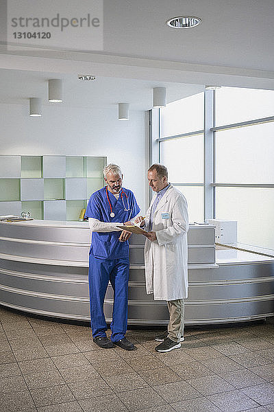 Männliche Ärzte bei der Besprechung von Krankenakten im Krankenhaus