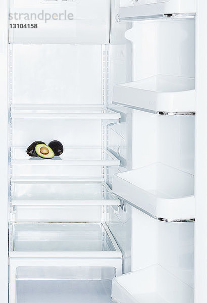 Avocados im offenen  leeren weißen Kühlschrank