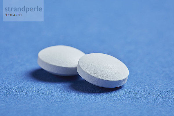 Close up zwei Pillen auf blauem Hintergrund