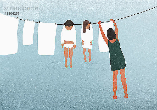 Frau hängt Kinder zum Trocknen auf die Wäscheleine