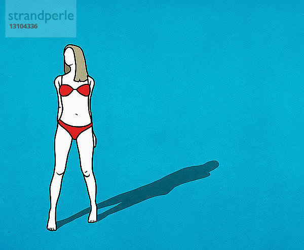 Selbstbewusste Frau im roten Bikini auf blauem Hintergrund