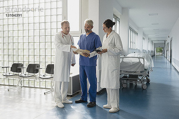 Ärzte besprechen Krankenakte im Krankenhauskorridor