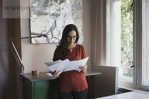 Geschäftsfrau liest Papierkram im Büro