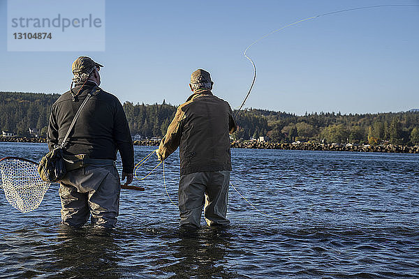 Ein Führer berät seinen Klienten beim Fliegenfischen im Salzwasser auf Meerforellen und Lachs im Nordwesten des Staates Washington  USA