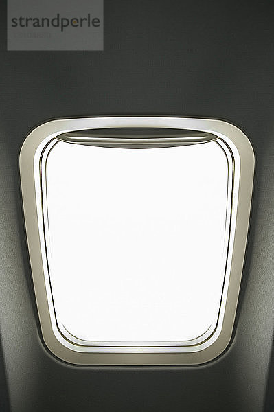 Innenraum einer Flugzeugkabine  ein kleines längliches Fenster.