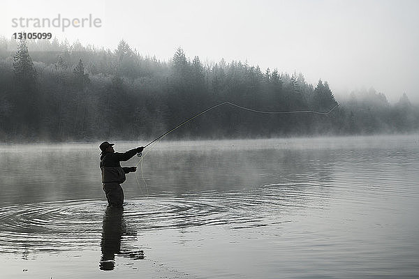 Silhouette eines Fischers beim Fliegenfischen auf Lachs und Cutthroat-Forelle