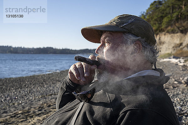 Ein Fliegenfischer genießt eine Zigarre und macht eine Pause vom Fliegenfischen auf Meerforelle und Lachs im Nordwesten der USA im Bundesstaat Washington