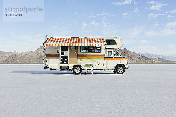 Vintage Dodge Sportsman RV mit gestreifter Überdachung auf Salt Flats geparkt