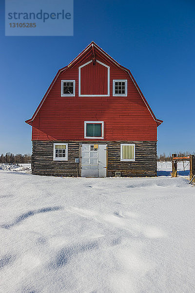 Eine Scheune mit rotem Dach in einem schneebedeckten Feld  Süd-Zentral-Alaska; Palmer  Alaska  Vereinigte Staaten von Amerika