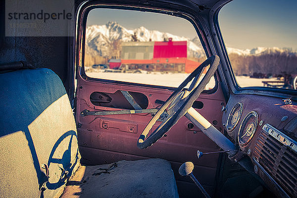 Innenansicht eines alten  abgenutzten Lastwagens mit Pioneer Peak  der aus dem Autofenster sichtbar ist  Süd-Zentral-Alaska; Palmer  Alaska  Vereinigte Staaten von Amerika