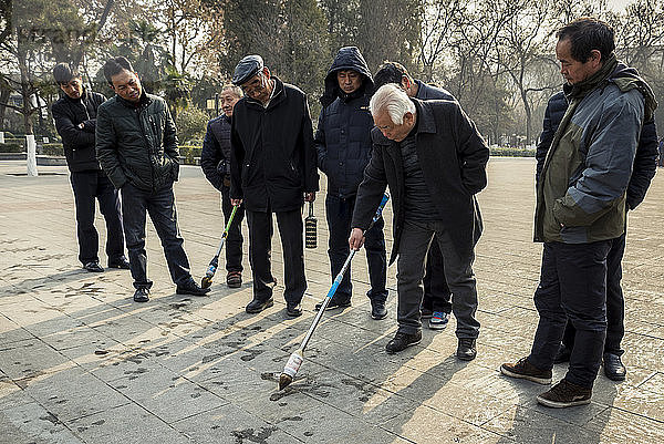 Chinesische Männer beim Üben von Kalligraphie im Revolutionspark; Xian  Provinz Shaanxi  China