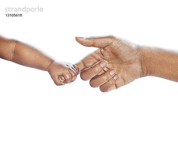 Mutter und Baby reichen sich die Hände auf einem weißen Hintergrund