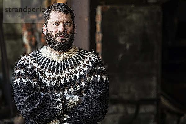 Porträt eines stehenden Mannes mit verschränkten Armen; Island
