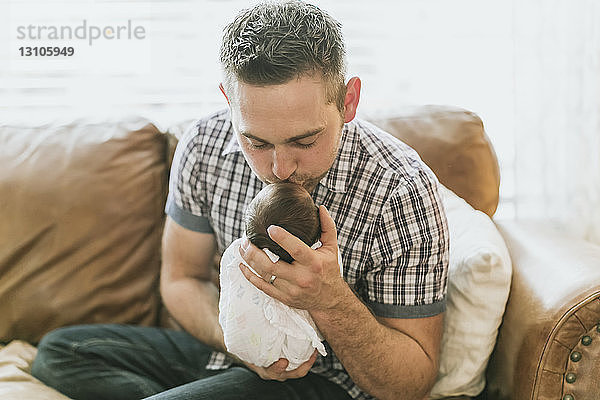 Porträt eines Vaters  der sein neugeborenes Baby hält und küsst; Surrey  British Columbia  Kanada