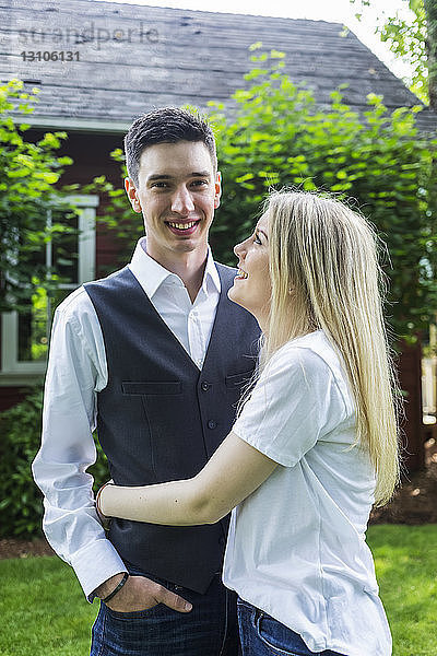 Porträt eines jungen Paares  das in einem Hinterhof steht; Bothell  Washington  Vereinigte Staaten von Amerika