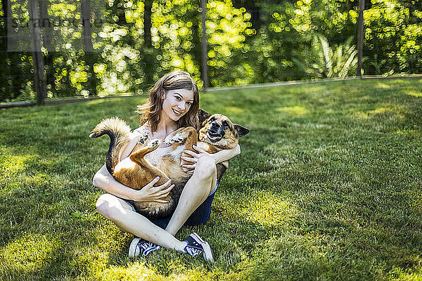 Teenager-Mädchen hält ihren Hund auf einer Wiese in einem Park; Surrey  British Columbia  Kanada