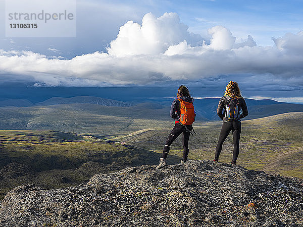 Zwei Frauen erkunden die Berge und die Wildnis des Yukon. Sie fühlen sich lebendig und dynamisch in der wunderschönen Landschaft um Haines Junction; Yukon  Kanada