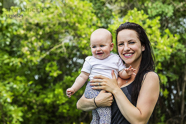 Porträt einer jungen Mutter  die im Sommer mit ihrer Tochter in einem Park Zeit verbringt und dabei in die Kamera schaut; Edmonton  Alberta  Kanada