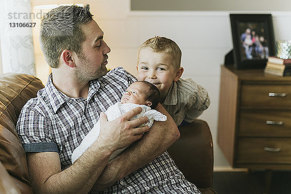 Vater hält sein neugeborenes Baby und sein älterer Bruder schaut zu; Surrey  British Columbia  Kanada