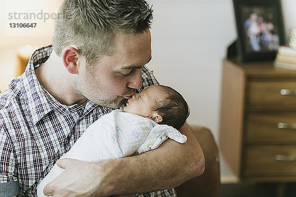 Porträt eines Vaters  der sein neugeborenes Baby hält und küsst; Surrey  British Columbia  Kanada