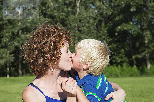 Eine Mutter umarmt und küsst ihren kleinen Sohn; Stony Plain  Alberta  Kanada