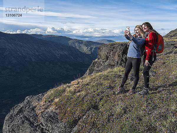 Zwei Frauen machen mit ihrem Handy ein Selbstporträt und erkunden die Berge und die Wildnis des Yukon um Haines Junction; Yukon  Kanada