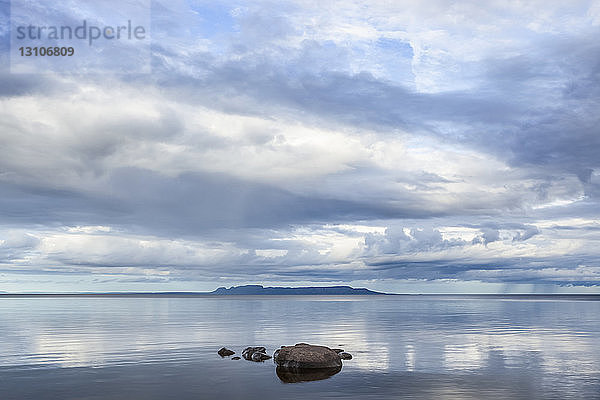 Ruhiger Lake Superior  in dem sich der Himmel spiegelt  mit der Nordküste in der Ferne; Thunder Bay  Ontario  Kanada