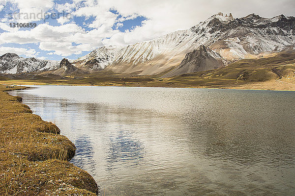 Ein einsamer Bergsee vom Ufer aus gesehen  die Berge sind mit einer Neuschneeschicht bedeckt; Malargue  Mendoza  Argentinien