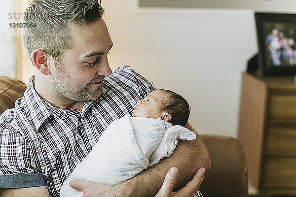 Porträt eines Vaters  der sein neugeborenes Baby im Arm hält; Surrey  British Columbia  Kanada