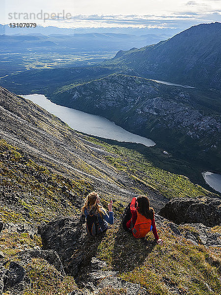 Zwei Frauen erkunden die Berge und die Wildnis des Yukon. Sie fühlen sich lebendig und dynamisch in der wunderschönen Landschaft um Haines Junction; Yukon  Kanada